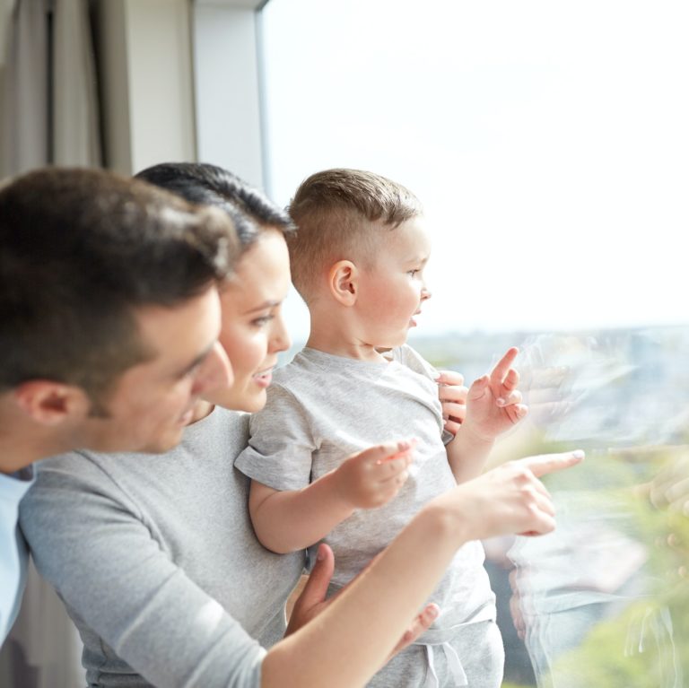 happy family looking through window at home